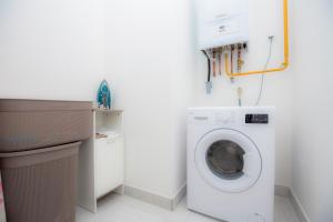 eine weiße Waschküche mit einer Waschmaschine in der Unterkunft Vanilla apartment in Šibenik
