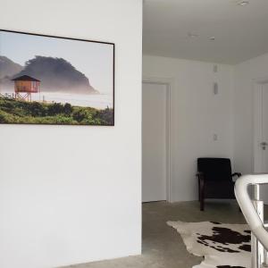 uma sala de estar com uma fotografia na parede em Casa Arrô - Pousada Boutique em Itajaí