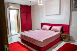 a bedroom with a red bed with a red headboard at Riad dar salam in Agadir