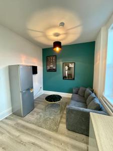 a living room with a couch and a refrigerator at Large, stylish 2bedroom apartment l free parking in Elswick