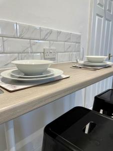 a wooden counter with two bowls and plates on it at Large, stylish 2bedroom apartment l free parking in Elswick