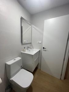 a white bathroom with a toilet and a sink at Loft Playa Villajoyosa in Villajoyosa