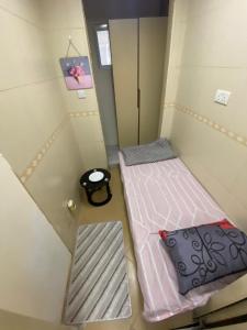 two beds in a small room with a trash can at MBZ - Cosy Separate Room in Unique Flat in Abu Dhabi