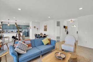 a living room with a blue couch and a kitchen at The Quail's Nest, Dreamy Backyard,10 Mins To Jtnp in Joshua Tree