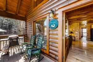 a porch of a cabin with green rocking chairs at Jolene Jolene in Pigeon Forge