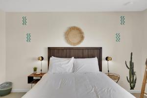 um quarto com uma cama com lençóis brancos e decalques azuis em The Quail's Nest, Dreamy Backyard,10 Mins To Jtnp em Joshua Tree