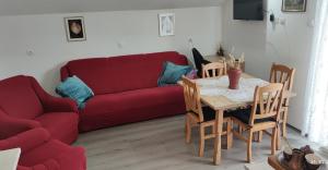 ein Wohnzimmer mit einem roten Sofa und einem Tisch in der Unterkunft Apartments with a parking space Plaski, Velebit - 20466 in Plaški