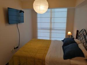een slaapkamer met een bed met een gele deken en een lamp bij Gorgeous 2 bedroom flat in nice commercial area in Lima