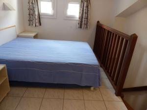 ein Schlafzimmer mit einem Bett mit blauer Bettwäsche und einer Treppe in der Unterkunft Appartement Le Lavandou, 2 pièces, 4 personnes - FR-1-308-114 in Le Lavandou