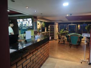 a bar in a restaurant with chairs and a man at Hotel Bolivariano in Ibagué