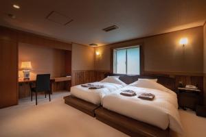 a bedroom with a large bed with a desk and a chair at IKI RETREAT by Onko Chishin in Iki