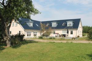 a large white house with a blue roof at LatterLy Apartments in Voel