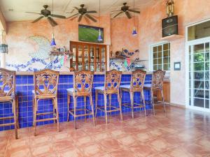 uma cozinha com um bar com cadeiras de madeira e azulejos azuis em Gone Fishing Panama Resort em Boca Chica