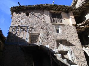 Edificio de piedra antiguo con ventana y balcón en DAR Awlim en Amassa