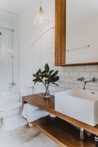uma casa de banho branca com um lavatório e um WC em The French House em Trentham