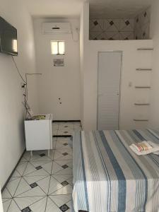 Cette chambre blanche dispose d'un lit et d'une porte. dans l'établissement POUSADA SÃO JOSÉ, à Tabuleiro do Norte