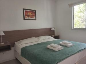 1 dormitorio con 1 cama con 2 toallas en Altos Serranos Apart en Merlo
