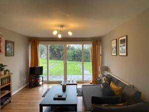 uma sala de estar com um sofá e uma grande janela em Atlantic Lodge em Newquay