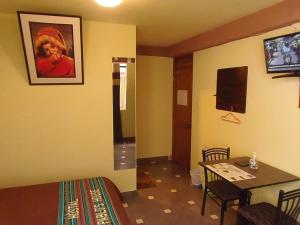a room with a dining table and a room with a tv at Hostal Pablo's House in Machu Picchu