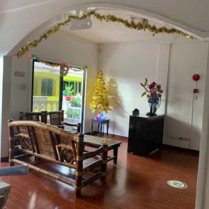 a living room with a bench and a christmas tree at Culpepper Lodge in Aklan
