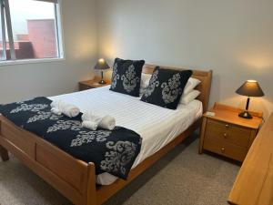 新普利茅斯的住宿－Seaside Wanaka Tce，一间卧室配有一张带两盏灯的床和一扇窗户。