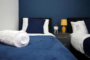 ein blaues Schlafzimmer mit 2 Betten und einer blauen Wand in der Unterkunft 2 Bed Apartment! Near City Centre! 5 Guests*Long stay discount* in Cardiff