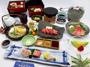 una mesa cubierta con diferentes tipos de comida en tazones en Okumizuma Onsen en Kaizuka