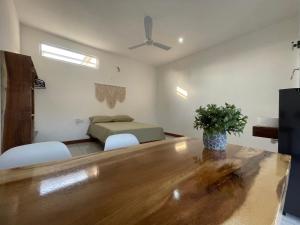 ein Wohnzimmer mit einem Tisch und einem Bett darin in der Unterkunft Casa Mura in Puerto Escondido