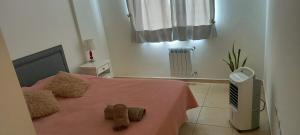 1 dormitorio con 1 cama con manta rosa en Alojamiento JUANA I en Neuquén