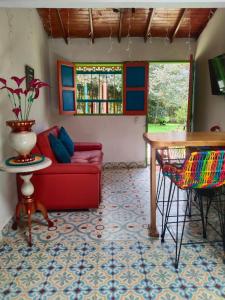 sala de estar con sofá rojo y mesa en Galilea en Santa Elena