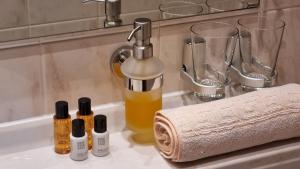 ein Waschbecken mit Flaschen ätherischer Öle und einem Handtuch in der Unterkunft Gasthaus Pension Moselgruss in Dieblich
