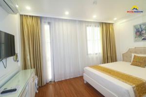 una camera d'albergo con letto e TV di Bài Thơ Mountain Hotel a Ha Long