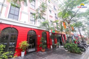 czerwony budynek na ulicy z drzewami i roślinami w obiekcie Bài Thơ Mountain Hotel w Ha Long