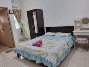 Sweethome Homestay Sandakan في سانداكان: غرفة نوم عليها سرير ومخدة وردية