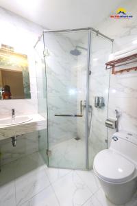 a bathroom with a shower and a toilet and a sink at Bài Thơ Mountain Hotel in Ha Long