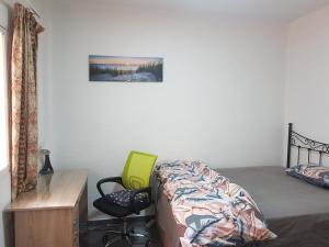 sypialnia z łóżkiem i zielonym krzesłem w obiekcie Kaz Bedrooms w Maladze
