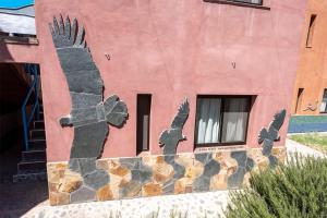 a painting of two birds on the side of a building at Casa de Peter in Cafayate