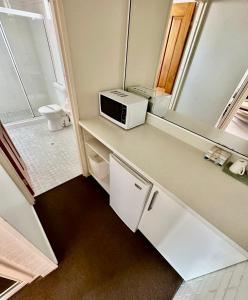 a small kitchen with a microwave on a counter at Top of the Town Motor Inn in Narooma