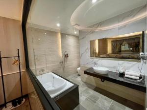 a bathroom with a tub and a sink and a mirror at 家園時尚旅店 in Puli