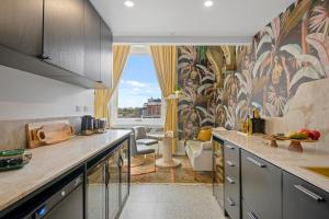 a kitchen with a view of a living room at Eve Apartment - Cathedral Square in Christchurch