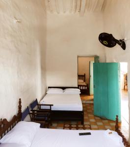 een kamer met 2 bedden en een groene deur bij Casa Orquidea Hostal Barichara in Barichara