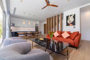 a living room with a couch and a table at Himmapana Villas - Hills in Kamala Beach