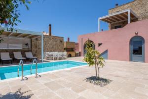 a villa with a swimming pool and a house at Patio Villas Complex in Stoupa