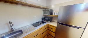 a kitchen with a stainless steel refrigerator and a sink at Casitas de madera in Punta Chame