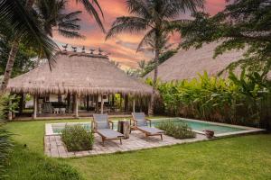 ein Resort mit 2 Stühlen und einer Hütte mit einem Pool in der Unterkunft Beach Villas Lombok in Tanjung