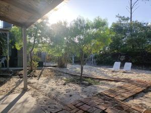 une terrasse avec 2 chaises blanches et des arbres dans l'établissement Los Caranchos I, à Cuchilla Alta