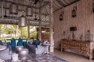 a living room with blue couches and a table at Beach Villas Lombok in Tanjung