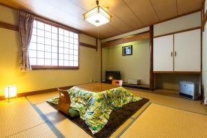 une grande chambre avec une table au milieu dans l'établissement Oyado Hisaya, à Kami