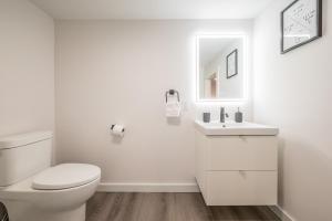 a white bathroom with a toilet and a sink at Modern Contemporary 2 Bedroom Suite in Halifax