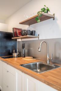 eine Küche mit einer Spüle aus Edelstahl und einer Arbeitsfläche aus Holz in der Unterkunft Modern Contemporary 2 Bedroom Suite in Halifax